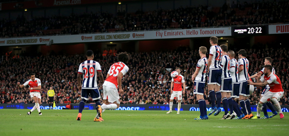 Arsenal-aanvaller Alexis Sánchez tekent uit een vrije trap voor zijn tweede treffer van de avond tegen West Bromwich Albion.