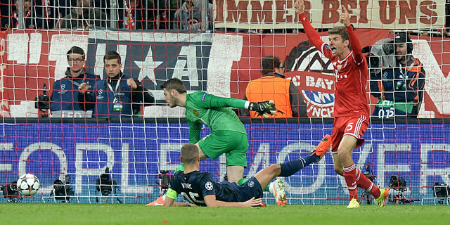 Thomas Müller viert de 2-1 terwijl Nemanja Vidic en David de Gea geslagen op de grond liggen.