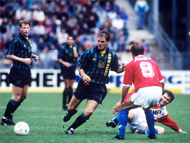 Marcel van der Net probeert de doorgebroken Frank de Boer, nu coach bij de Amsterdammers, af te stoppen in het seizoen 1993/94. Vanaf de grond kijkt de inmiddels overleden Wlodi Smolarek toe. Ook Stefan Petterson volgt de verrichtingen op de voet. 