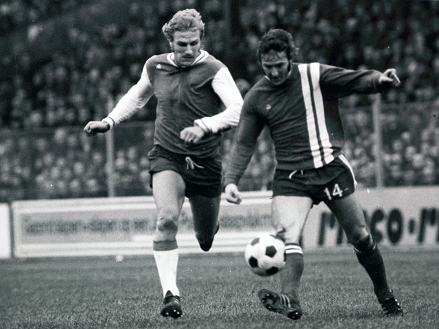 Op 20 januari 1973 was het spannend aan kop in de Eredivisie. Maar omdat FC Twente en Feyenoord de punten deelden (1-1) ging Ajax na speelronde negentien met de koppositie aan de haal. Aan het einde van dat seizoen zou dat wel anders zijn. Feyenoord pakte de titel en FC Twente eindigde als nummer twee met twee punten minder dan de kampioen. Hier zoekt Jan Boskamp (links) naar het juiste moment om Eddy Achterberg de bal te ontnemen.