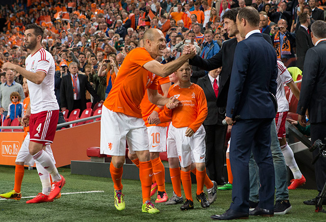 Lachende gezichten bij Oranje voor het uitzwaaiduel met Wales. Arjen Robben begroet Mark van Bommel, die voor de wedstrijd in het zonnetje wordt gezet voor zijn bijdrage als international.